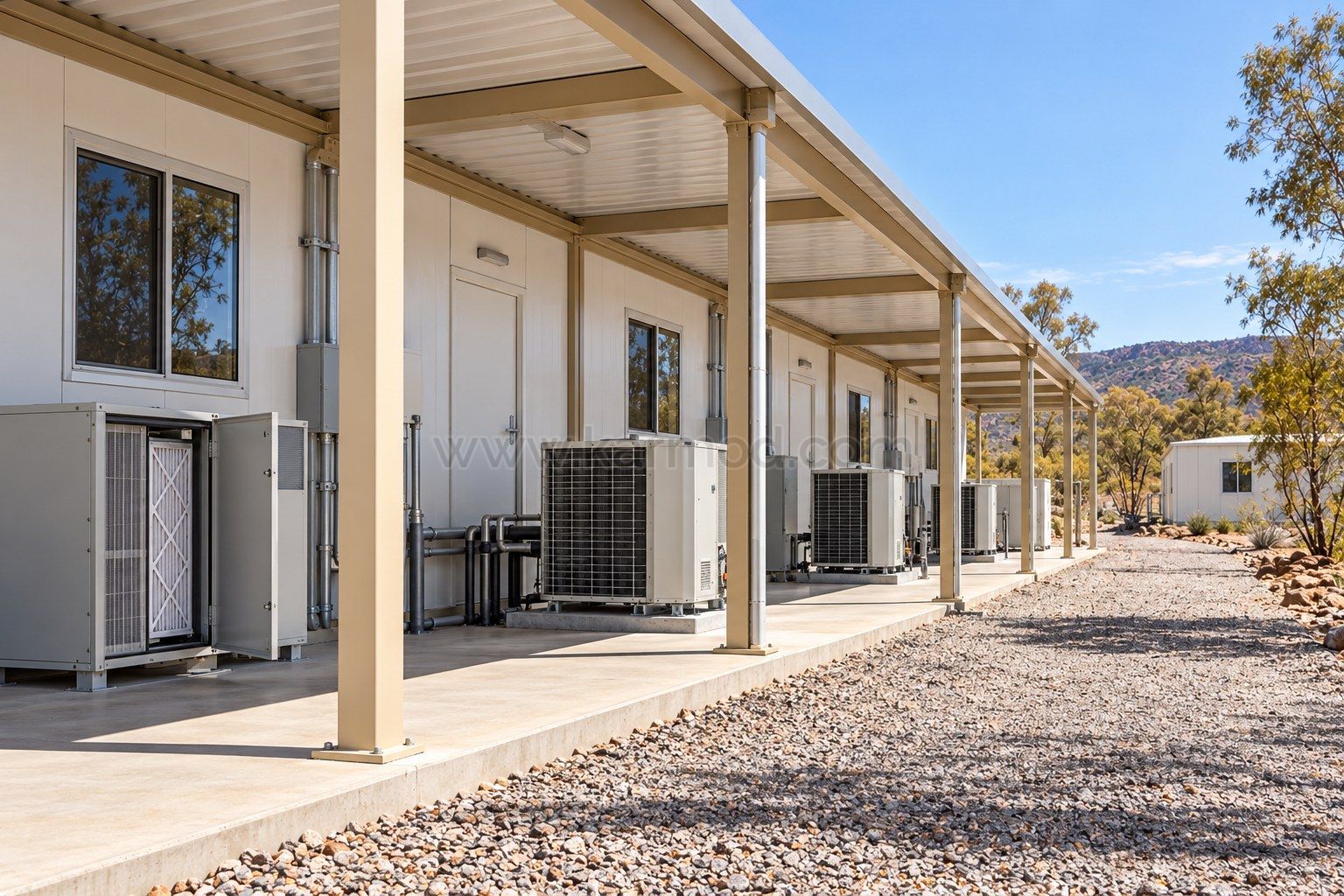 Zona técnica de módulos con equipos de climatización accesibles y pasillo de mantenimiento sombreado.