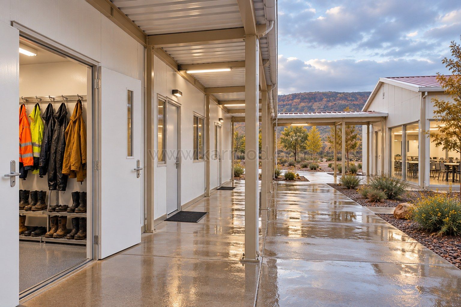 Acceso a vestuario modular con espacio para ropa de lluvia y camino cubierto entre edificios.